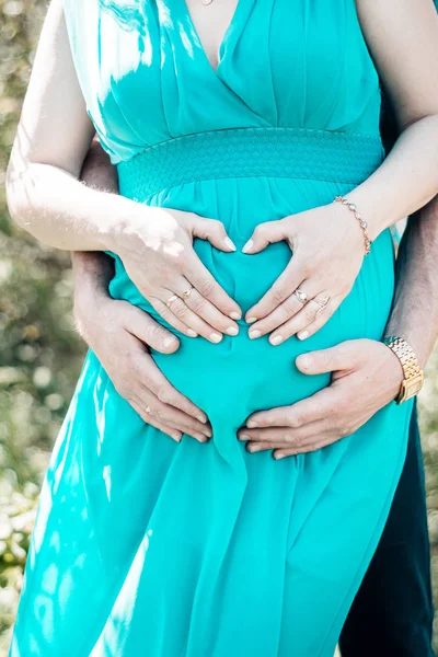一个男人抱着一颗心在孕妇肚子上的样子 — 图库照片