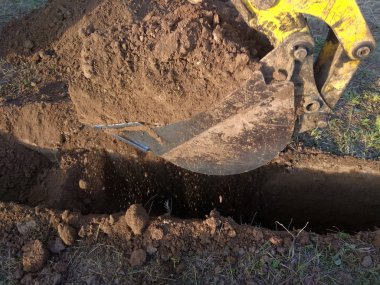 Bir binanın temeli için hendek kazan bir kazıcı.