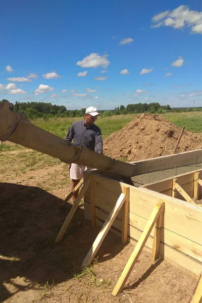 Bygga konstruktion arbetaren hälla cement eller betong med pumpen rör — Stockfoto