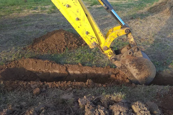 Une excavatrice creuse une tranchée dans une maison de campagne — Photo