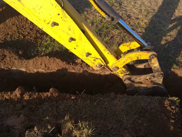 Une excavatrice creuse une tranchée dans une maison de campagne — Photo