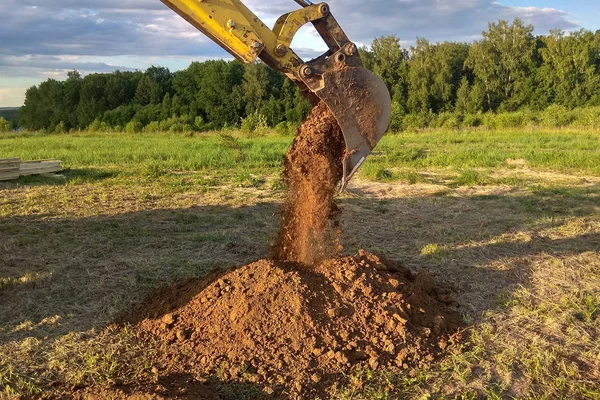 Un escavatore di lavoro scava una trincea per la fondazione di un edificio — Foto Stock