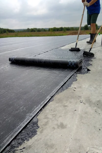 Roofer trabajador pintura betún praimer en la superficie de hormigón por el cepillo de rodillos Impermeabilización — Foto de Stock