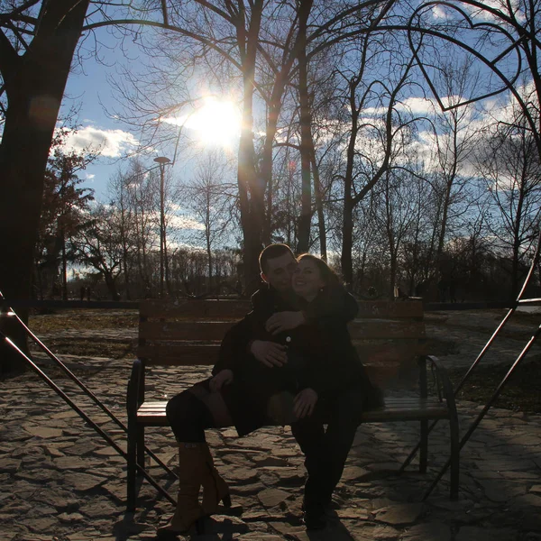 日当たりの良い公園のベンチの上に座って、一緒に心のジェスチャーを作る美しい幸せの若いカップル — ストック写真