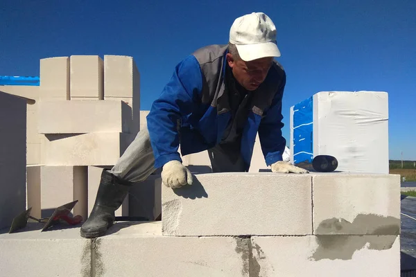 The worker checks the wall of gas blocks by a leveler 2018