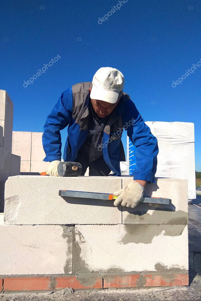 The worker checks the wall of gas blocks by a leveler 2018