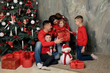 Eğlenceli bir genç aile ile Noel ağacı başına oturmuş hediyeler 2018