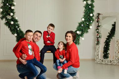 Mutlu aile içinde aynı kazak Noel tatili 2018 ortasında kışın bir salıncak oturmak