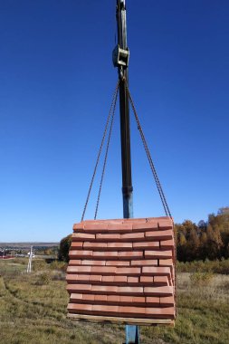 Araba vinç tutar ve arka planda gökyüzünün mavi sonbahar 2018 tuğla kaldırır