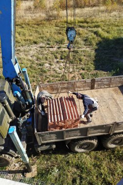 Araba vinç tutar ve arka planda gökyüzünün mavi sonbahar 2018 tuğla kaldırır