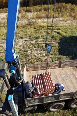 Araba vinç tutar ve arka planda gökyüzünün mavi sonbahar 2018 tuğla kaldırır