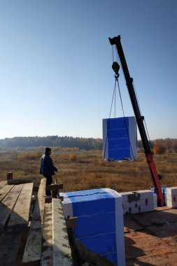 the employee controls the unloading of blocks for the construction of a house at the time farm 2018 clipart
