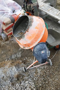 auxiliary worker develops a cement mortar in a concrete mixer at the construction of a country house 2018 clipart