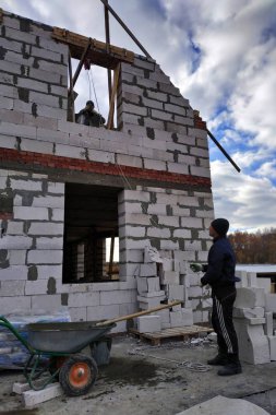 Bir işçi bir el vinç kullanarak bir çimento harç bin ikinci katta 2018 yükseltir