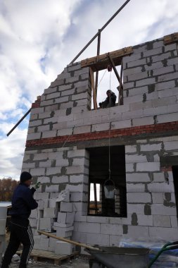 Bir işçi bir el vinç kullanarak bir çimento harç bin ikinci katta 2018 yükseltir