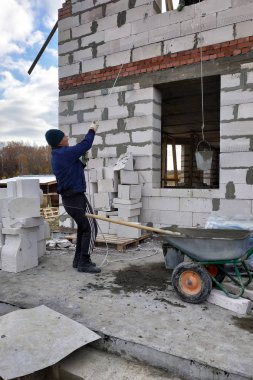 Bir işçi bir el vinç kullanarak bir çimento harç bin ikinci katta 2018 yükseltir