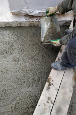 Builder bir çimento harç döşeme 2018 bir kova kullanarak evin zemin arasında dökülen