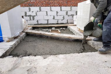 Builder bir çimento harç döşeme 2018 bir kova kullanarak evin zemin arasında dökülen