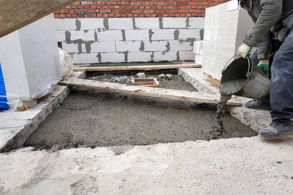 Builder bir çimento harç döşeme 2018 bir kova kullanarak evin zemin arasında dökülen