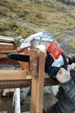 İşçiler kirişleri 2019 chainsaw evin çatısına kesti.