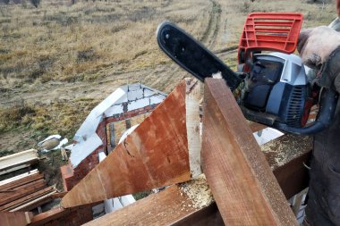İşçiler kirişleri 2019 chainsaw evin çatısına kesti.