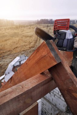 İşçiler kirişleri 2019 chainsaw evin çatısına kesti.