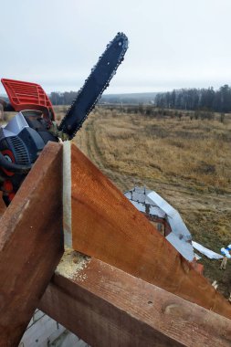 İşçiler kirişleri 2019 chainsaw evin çatısına kesti.