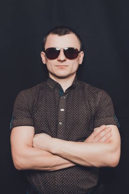 siyah bir gömlek ve kahverengi güneş gözlüğü 2018 giymiş seksi bir adam portresi