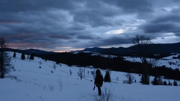 雪の山のふもとにあり 夜明けの谷の小さな村での時間経過を席巻します 星いっぱいの夜空はフレームを通して太陽が昇ると黄金になります — ストック動画
