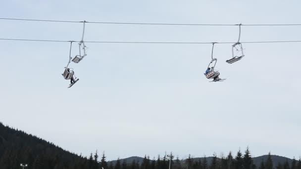 冬季滑雪胜地的人们在雪坡上滑雪和滑雪板 雪山上的滑雪电梯 滑雪胜地的冬季活动 — 图库视频影像
