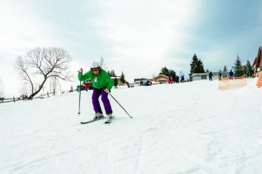 Profesyonel bir kıyafet içinde bir adam Ukraynalı dağlarda kayak dağ üzerinden atılıyor