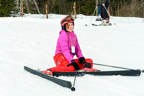 Junge schöne Frau im roten Outfit stürzte beim Skifahren in den Karpaten — Stockfoto
