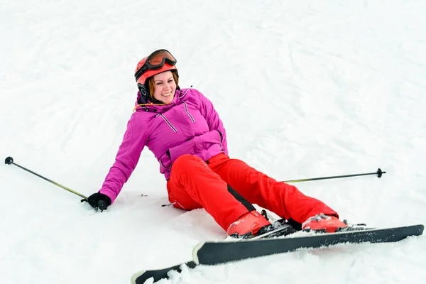 Młoda piękna kobieta w czerwonym stroju spadł podczas jazdy na nartach w Karpatach — Zdjęcie stockowe