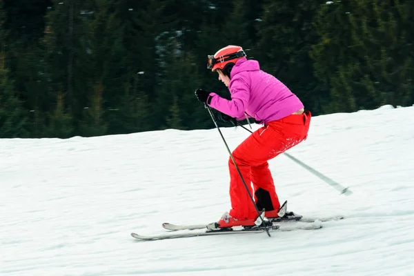 Eine schöne Frau in roter Kleidung lernt Skifahren in den ukrainischen Karpaten — Stockfoto