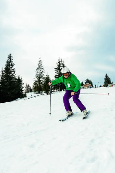 Ein Mann in professionellem Outfit eilt vom Skifahren in den ukrainischen Bergen — Stockfoto