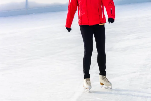 A young slender girl skates and helps beginners 2019