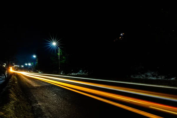 Magnífico agitar la luz de las luces del coche por la noche en la carretera con las estrellas de farolas — Foto de Stock