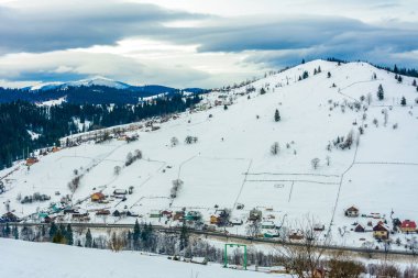 Şafakta kışın Karpatlar Ukraynalı dağ köyünde muhteşem manzara