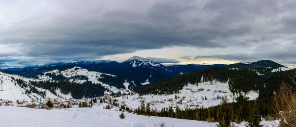 Amazing landscape of the Ukrainian mountain village in the Carpathians in the winter at dawn