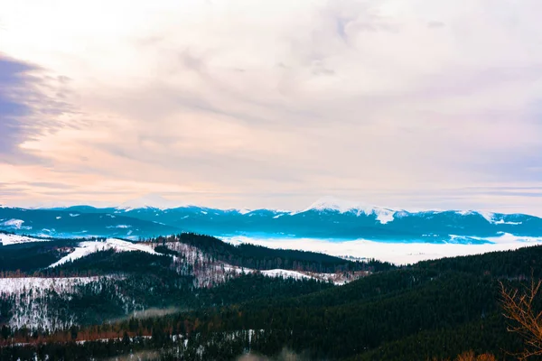 Increíble paisaje desde la plataforma de observación de uno de los resorts Cárpatos del cielo nublado y las montañas nevadas — Foto de Stock