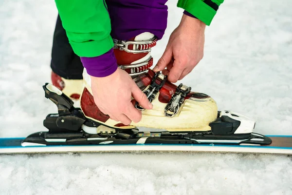 Der Skifahrer trägt Schuhe zum Skifahren und fixiert den Verschluss — Stockfoto