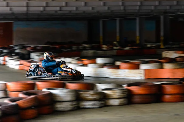 Gara dinamica di kart a velocità con movimento sfocato su un ippodromo attrezzato — Foto Stock