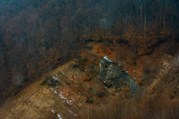 Η πέτρα γρανίτη δραματική βουνό που ξεχωρίζει από το γρασίδι ανάμεσα στα δέντρα — Φωτογραφία Αρχείου