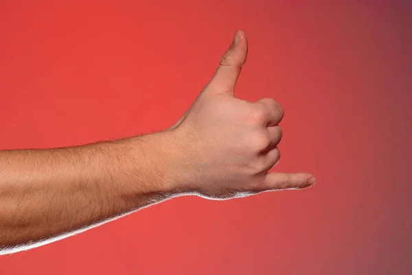 The sign of a phone call shows one-handed isolated on a red background — Stock Photo, Image