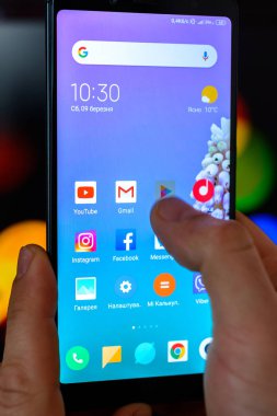 Lviv, Ukrayna - 09 Mart 2019: Adam akıllı telefon onun elleri yakın çekim tutar ve bulanık bir arka plan üzerinde Google oyun için belgili tanımlık kullanma açık