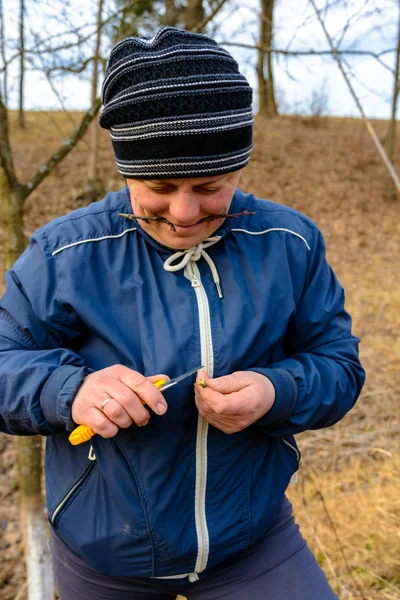 Жінка садівник вирізає затискач деревини для щеплення гострим ножем — стокове фото