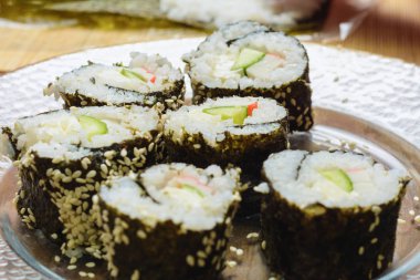 Kendi elleri ile bir kadının Şef tarafından pişirilmiş suşi rolleri mutfakta bir tabak