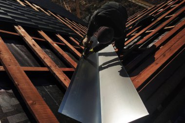 Usta bir metalik levha çatı yağmur sırasında drenaj için kırılma noktasında yükseltir