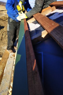 Profesyonel işçiler vida bir panosunda bir matkap ile büküm kiremit, metal yaprak mount