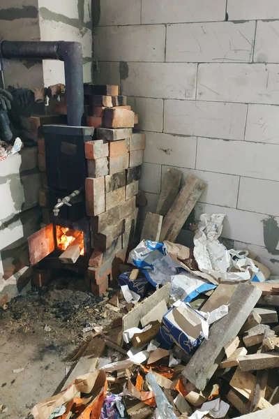 O fogão a lenha queima com portas abertas em violação da segurança e representa uma ameaça para o edifício através do fogo potencial, resultando em um incêndio . — Fotografia de Stock